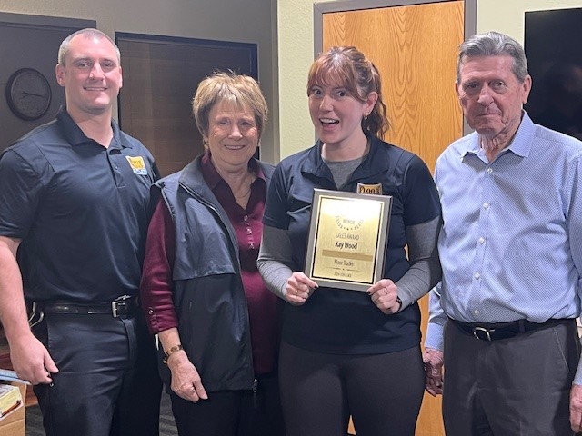 Kay Wood assistant Manager of The Floor Trader of Colorado Springs holding award with our team